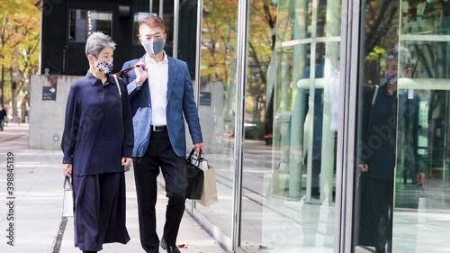 ウィンドウショッピングを楽しむマスクをつけた日本人シニア夫婦