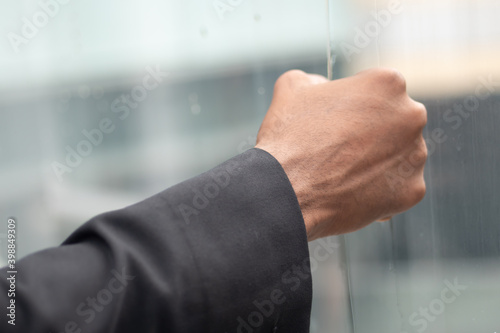 Angry hand of African black businessman  portrait of failed unhappy black business man punching glass window  concept of work problem  office stress syndrome  economic recession  layoff  unemployment