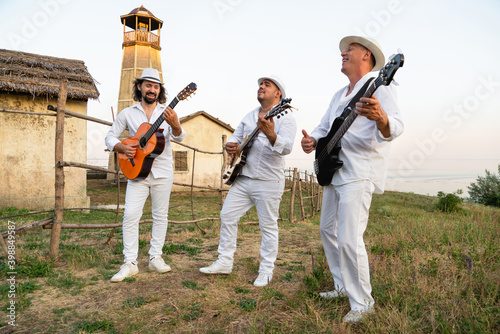 Musicians in white clothes and white hats play the guitars. Cuban musicians on the coast © scharfsinn86