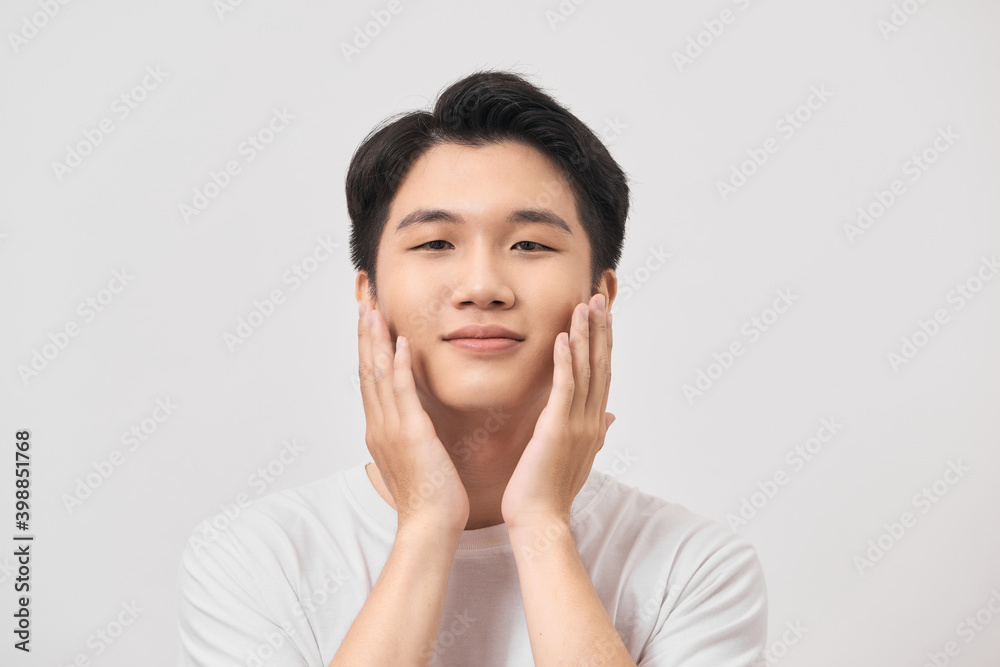 Happy and amazed asian young man touching his face, shocked with unexpected promotion on white background Happy and amazed asian young man touching his face, shocked with unexpected promotion on white background