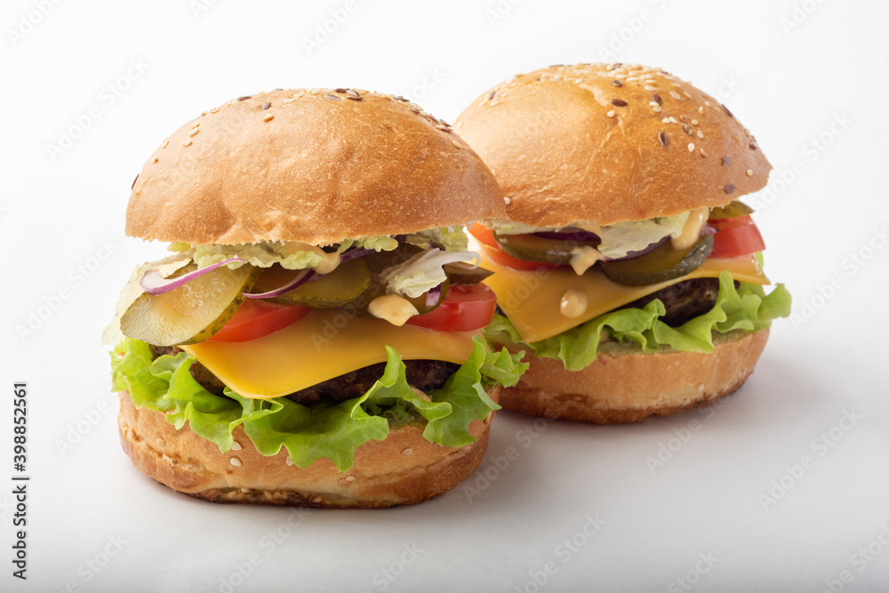 Classic burgers on a white background for isolation. Burgers with cucumbers and onions. Two burgers on a white background Classic burgers on a white background for isolation. Burgers with cucumbers and onions. Two burgers on a white background