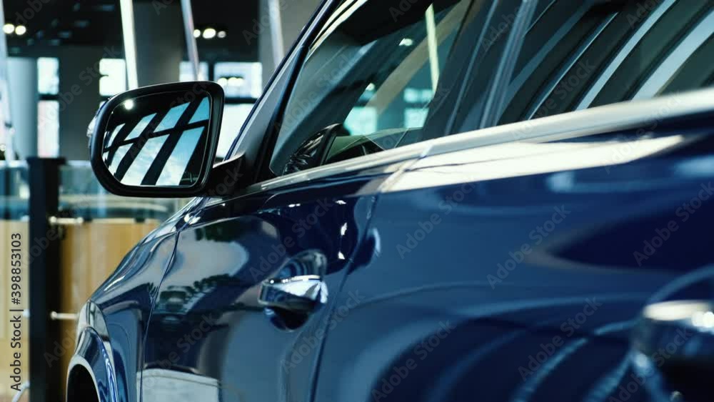 Side door windows and rearview mirror of a new SUV from a premium car brand. Sale of new cars in the dealer showroom. Side door windows and rearview mirror of a new SUV from a premium car brand. Sale of new cars in the dealer showroom.