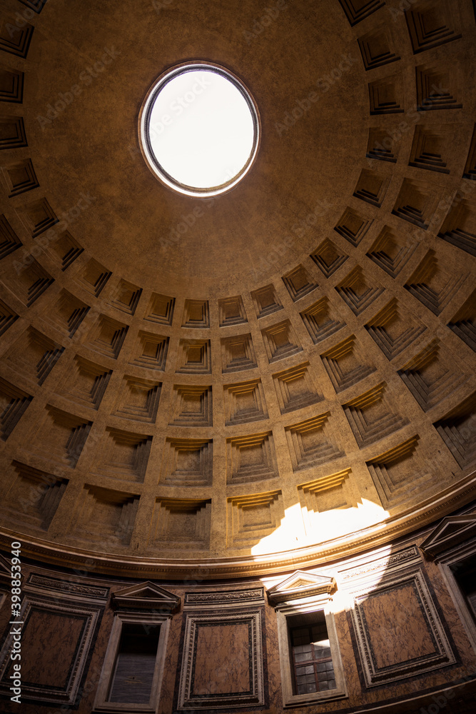 The famous cassette ceiling dome of Pantheon temple of all the gods with wide open rotunda on the top. Sunlight rays penetrating through oculus aperture on the roof