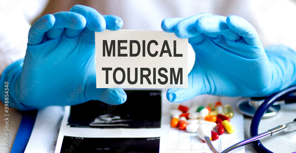 text MEDICAL TOURISM write on a medicine card. Medical concept with a stethoscope and pills