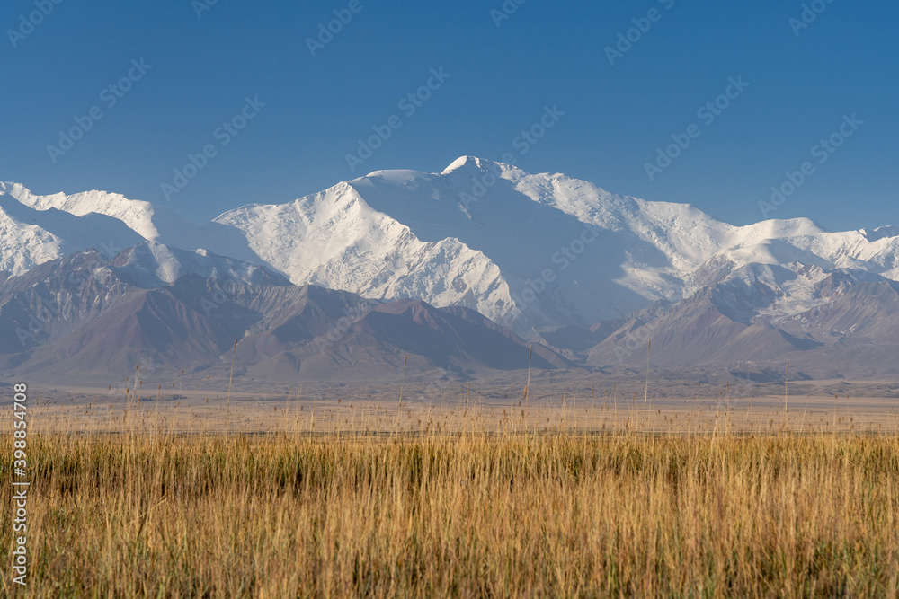 Morning landscape view of scenic snow-capped Trans-Alay mountain range with Lenin Peak aka Ibn Sina Peak, south Kyrgyzstan