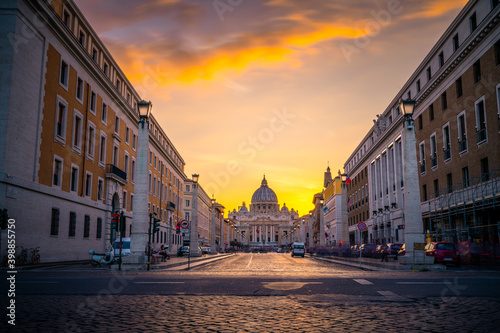 St. Peter's basilica at sunset viewed across Via della Conciliazione street 