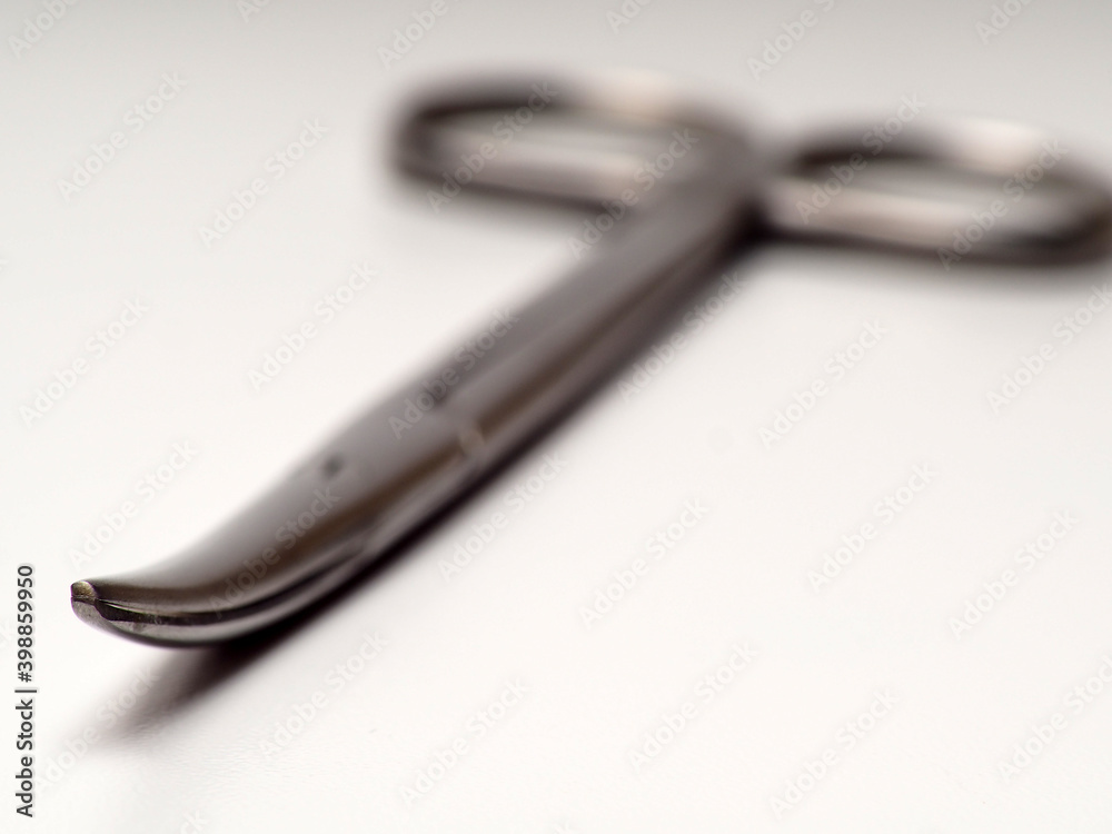 Close up shot of curved stainless steel medical scissor on an isolated white background Close up shot of curved stainless steel medical scissor on an isolated white background