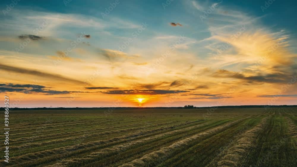 Aerial View Of Sunset Bright Sky Above Summer Hay Field Landscape In Evening. Drone Hyper lapse Aerial View Of Sunset Bright Sky Above Summer Hay Field Landscape In Evening. Drone Hyper lapse