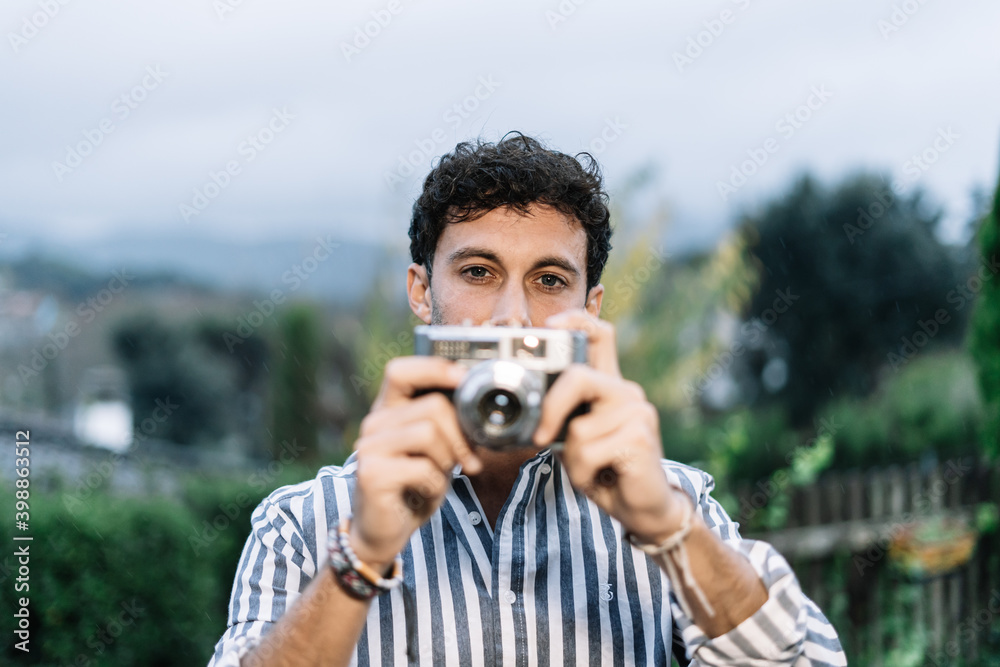 young photographer is taking a picture with a retro camera young photographer is taking a picture with a retro camera