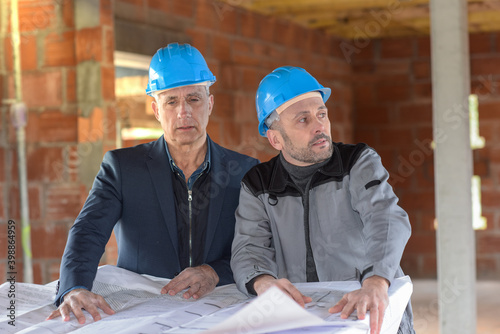 Architect and contractor looking at plans on a building site