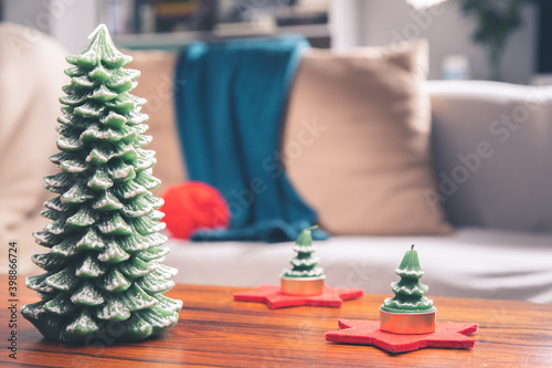 Vela navideña con forma de pino de Navidad sobre bonita mesa de madera y palisandro en un hogar de familia photo