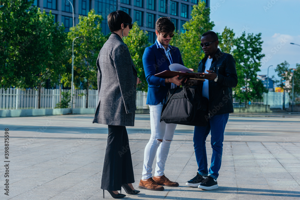 Fototapeta premium Group of successful business people discussing work outside their office building.