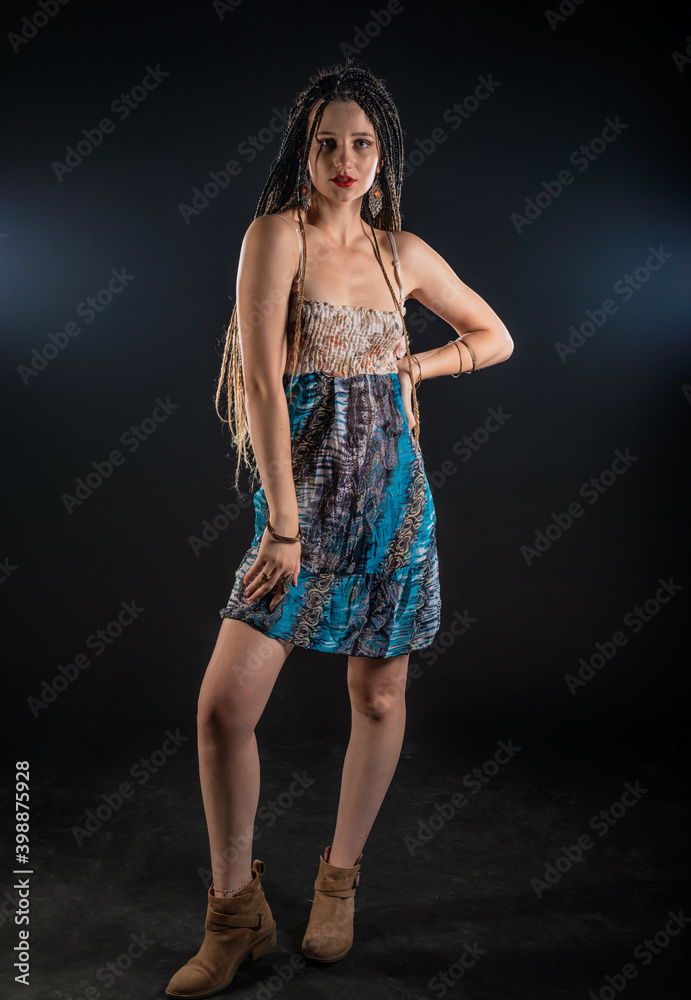 Portrait of a charming girl with braids with a mystic look at the camera. Studio black background.. Portrait of a charming girl with braids with a mystic look at the camera. Studio black background..
