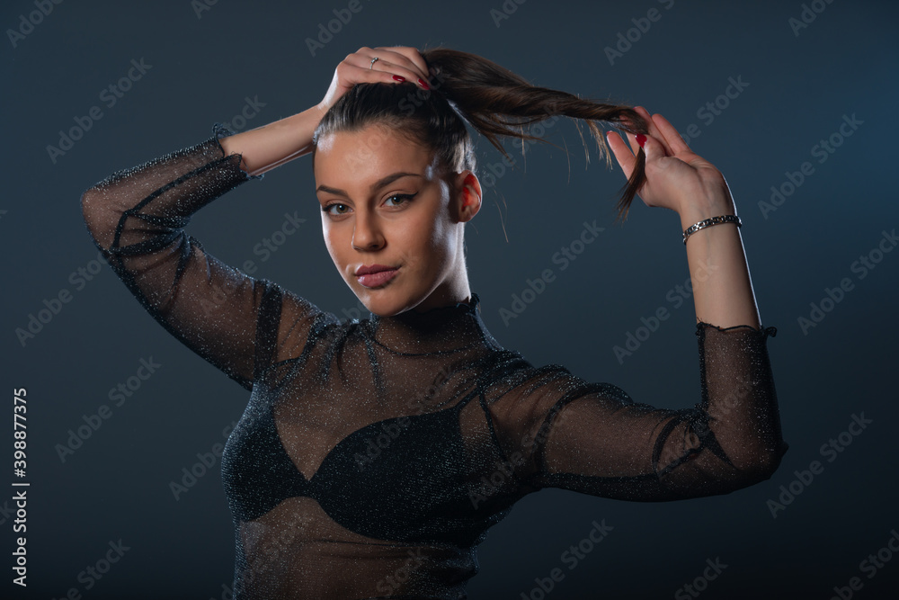 Fashion portrait of an attractive brunette girl holding and pulling her ponytail. Fashion portrait of an attractive brunette girl holding and pulling her ponytail.