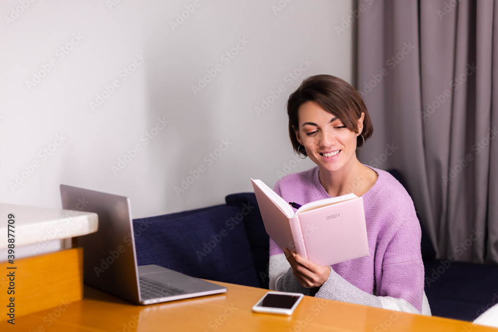 Woman at home with notepad notebook thinking about plans for 2021 year, laptop on the table. Woman at home with notepad notebook thinking about plans for 2021 year, laptop on the table.