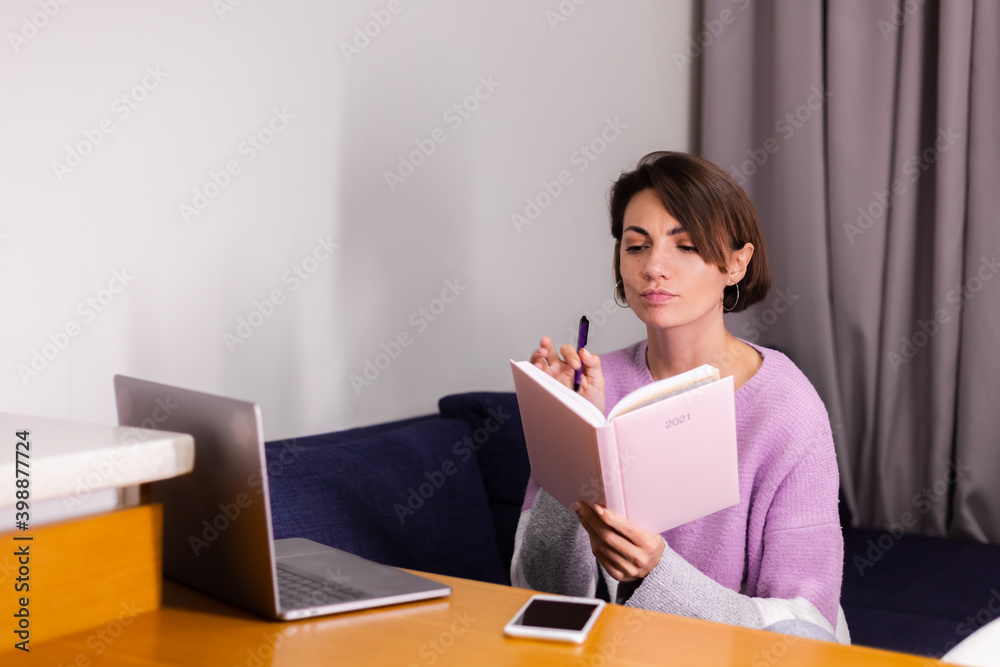 Woman at home with notepad notebook thinking about plans for 2021 year, laptop on the table. Woman at home with notepad notebook thinking about plans for 2021 year, laptop on the table.