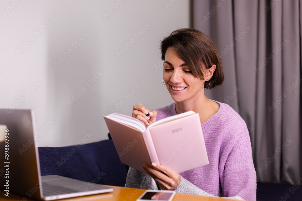 Woman at home with notepad notebook thinking about plans for 2021 year, laptop on the table. Woman at home with notepad notebook thinking about plans for 2021 year, laptop on the table.