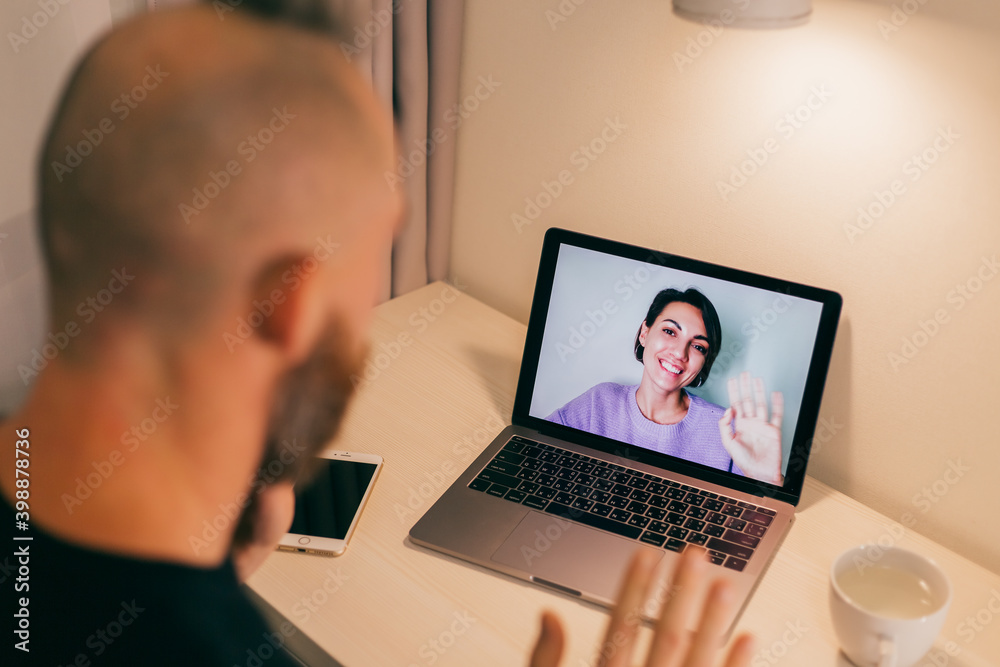 Man facetime at home, calling his friend wife girlfriend from laptop in bedroom. 