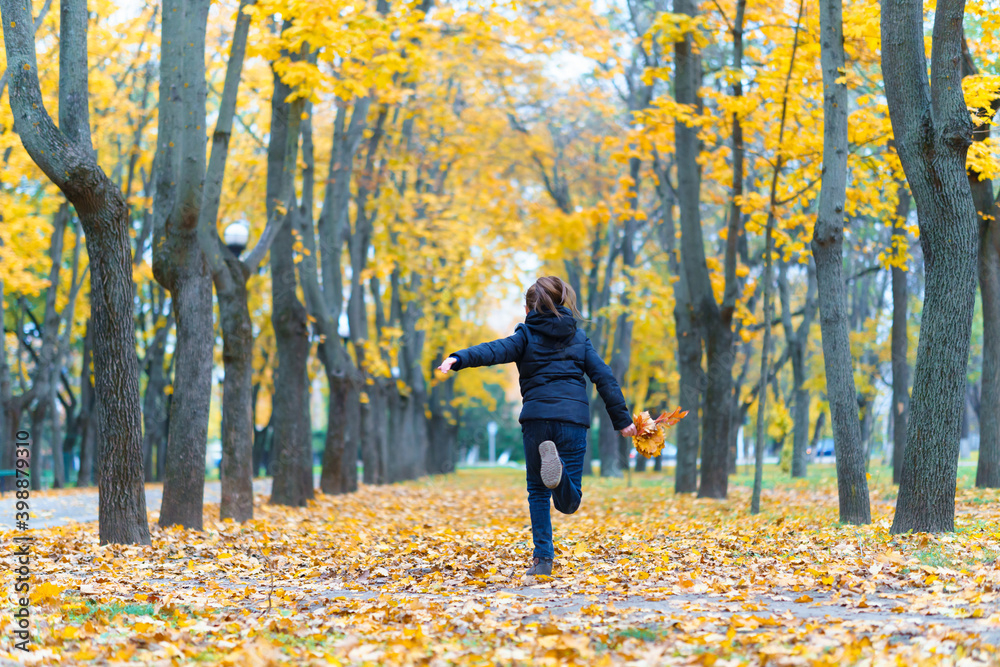a girl running through the park and enjoys autumn, beautiful nature with yellow leaves a girl running through the park and enjoys autumn, beautiful nature with yellow leaves