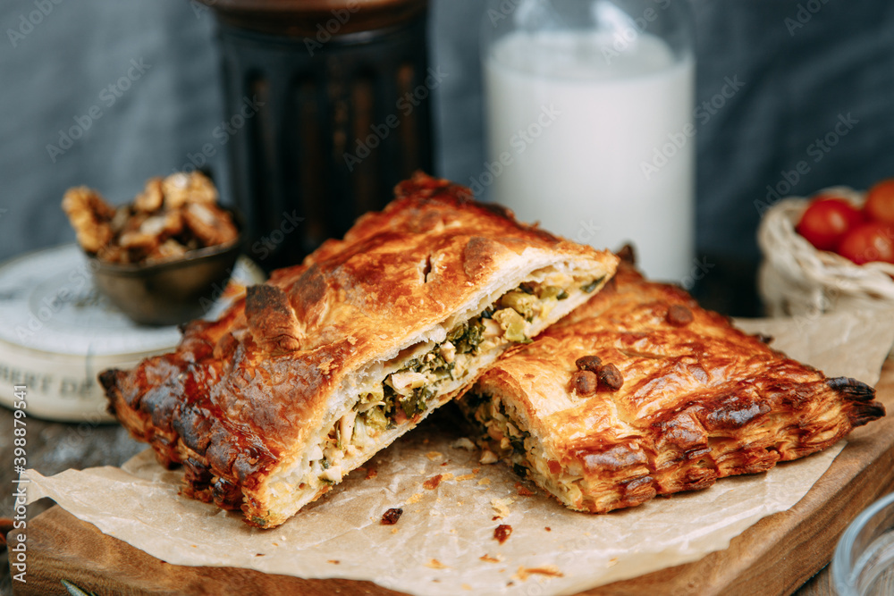 Hot chicken puff pastry pie. Pie with vegetables on a wooden table. Hot chicken puff pastry pie. Pie with vegetables on a wooden table.