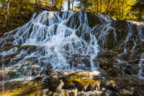 detail from a large waterfall in the autumn sun while hiking