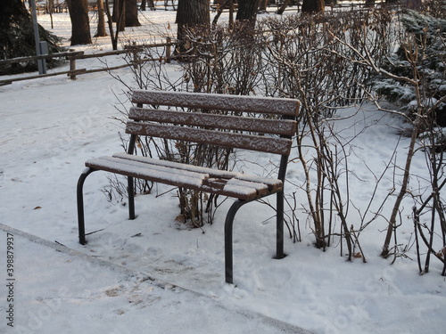 Wooden bench in the snow. First snow. Change of seasons.