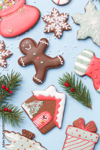 Beautiflly decorated gingerbread cookies on wintery blue background. Tasty homemade Christmas cookies close up view. 
 photo