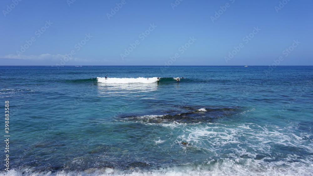 Blue ocean and waves on a sunny summer day in Playa de Las Americas, Tenerife, Spain. 