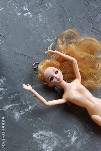 plastic doll on grey background