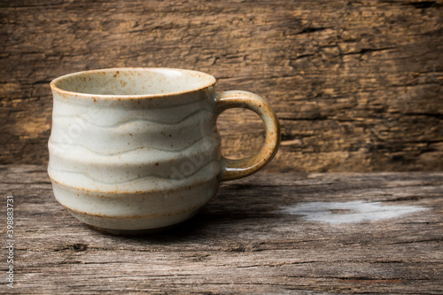 handmade ceramic coffee cup on wooden table.