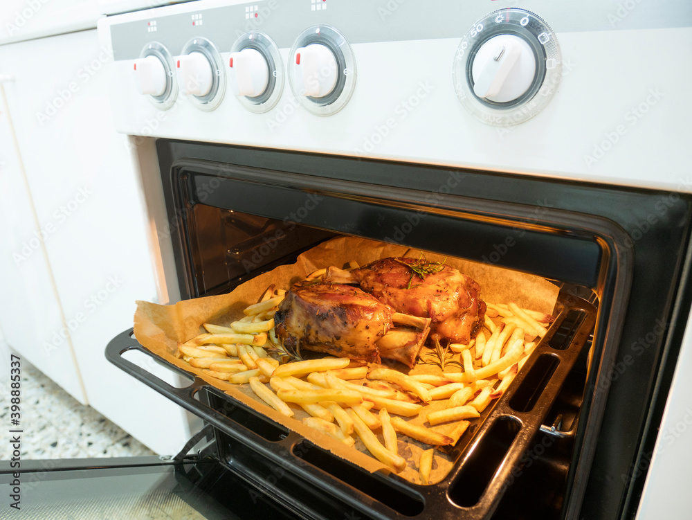 Baked pork knuckle ready to eat, just taken out of the hot oven, Bavarian recipe meat in the oven, domestic user concept, household appliance in the kitchen Baked pork knuckle ready to eat, just taken out of the hot oven, Bavarian recipe meat in the oven, domestic user concept, household appliance in the kitchen