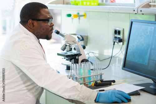 African-american man working in lab. Scientist doctor making medical research. Laboratory tools  microscope  test tubes  equipment. Biotechnology  chemistry  science  experiments and healthcare.
