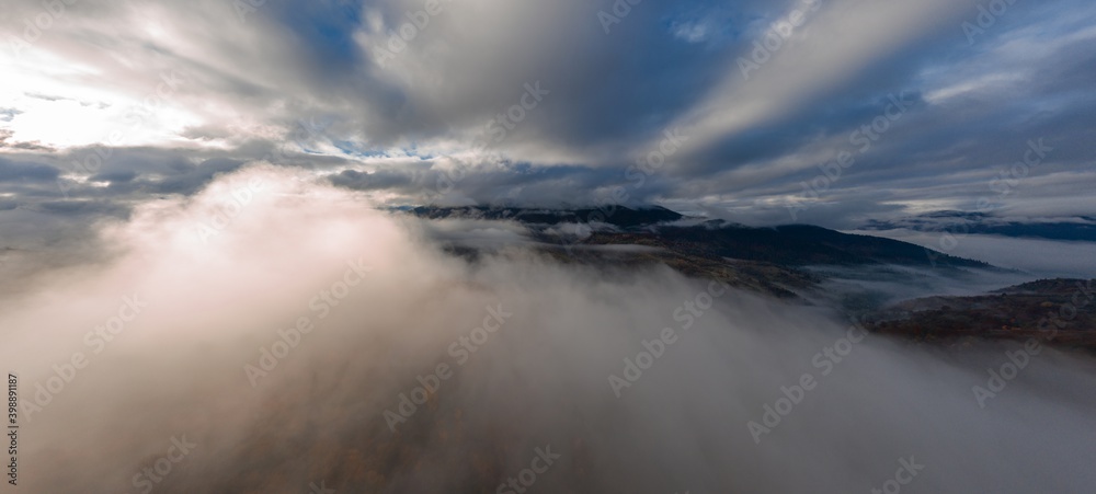 Flight through blue sky with clouds over mountain