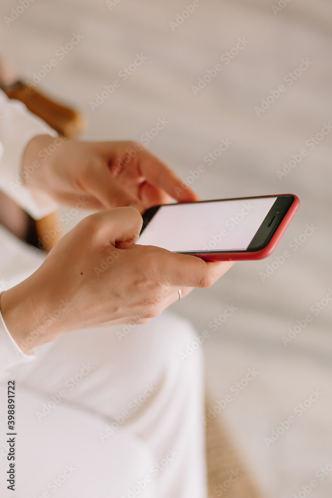 Woman holding a mobile phone with a red case Woman holding a mobile phone with a red case