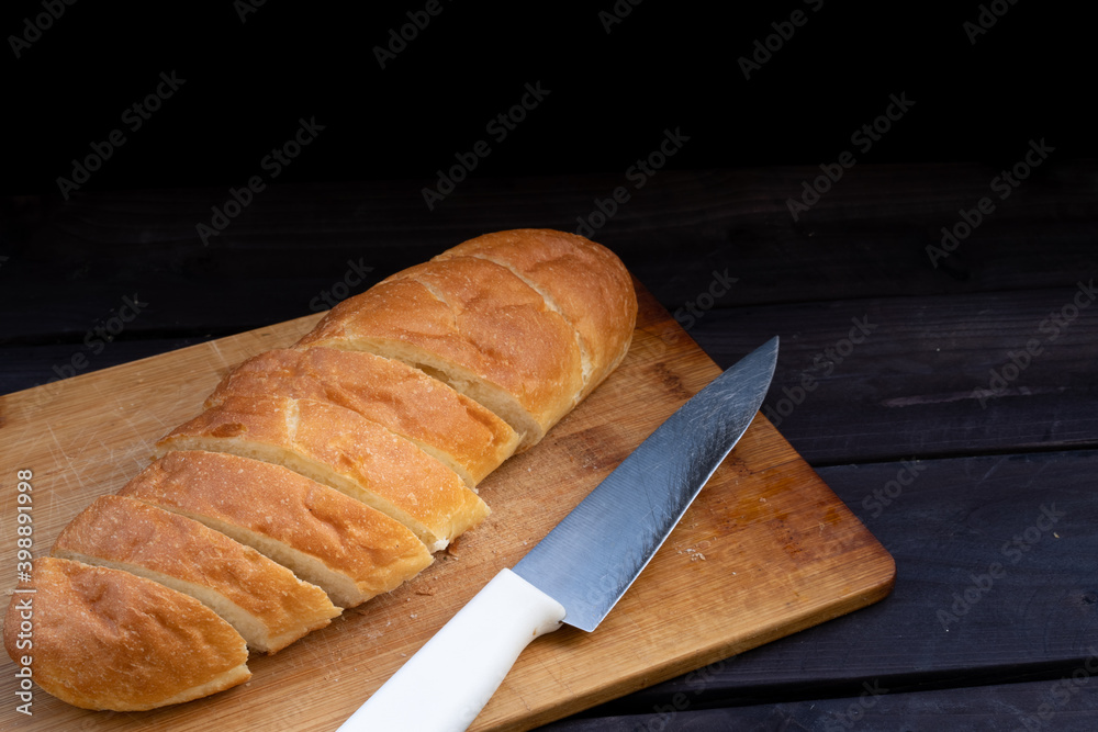 Loaf of bread and knife on a board