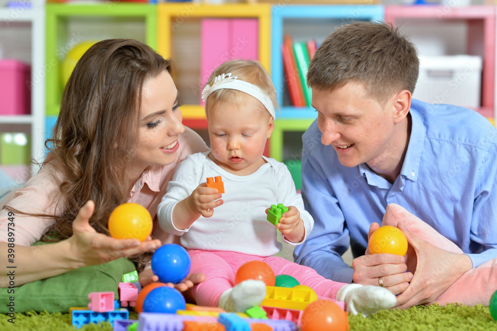Parents playing with adorable little daughter at playroom Parents playing with adorable little daughter at playroom