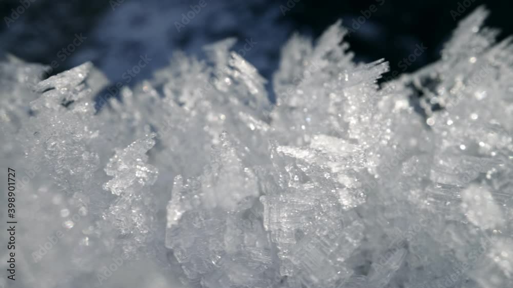 Snow cover macro shot. Ice formations of snow flakes shine in the sun. Winter nature background. Slidning UHD shot