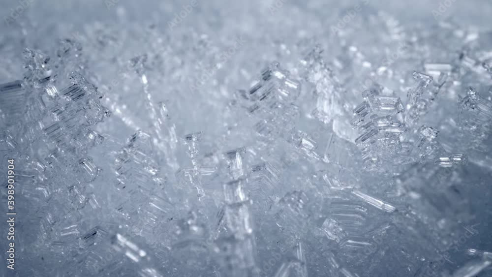 Super macro sliding shot of snow crystal, snowflakes. Camera moves through bizarre frozen flakes of snow. Ice formations, frost. Winter nature background. UHD