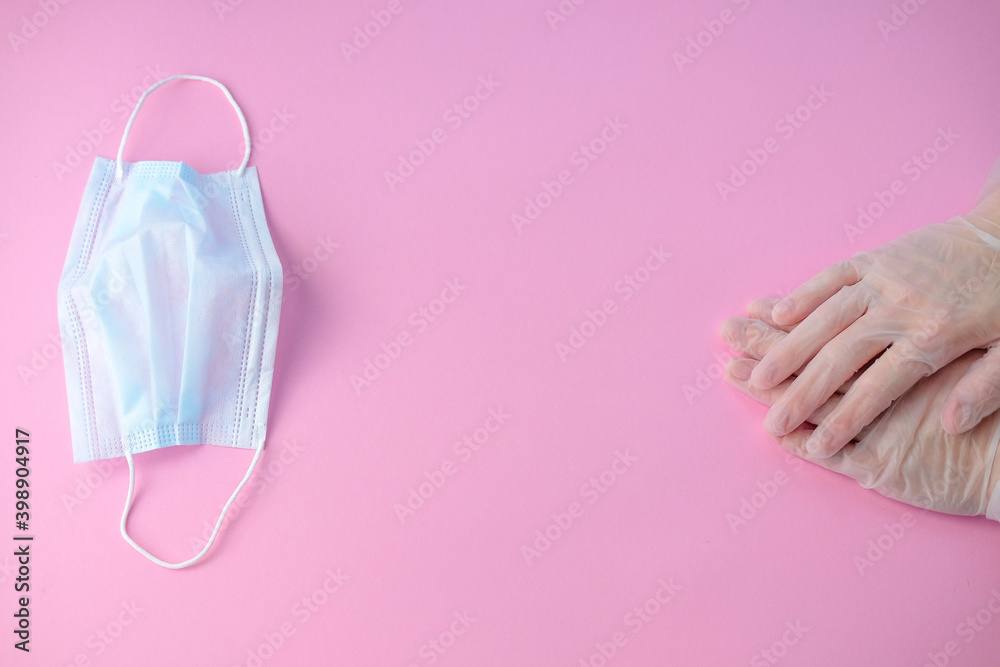 protective masks, medical gloves doctor's hands on a pink background . the theme of the coronavirus and infection .