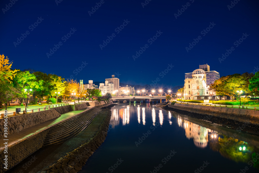 Hiroshima Skyline by night on the side of Motoyasu river in Japan with the ruin of the Atomic Bomb Dome, the historic remains of the atomic blast