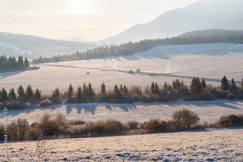 Winter landscape with snow covered field at sunrise © Gatis