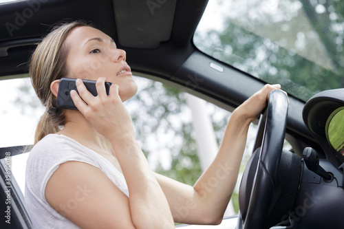 woman driver using smart phone in car during driving © auremar