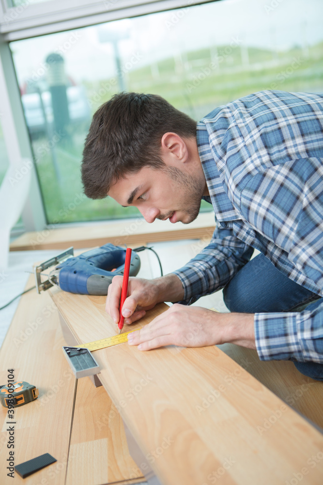 young man cutting wood board young man cutting wood board