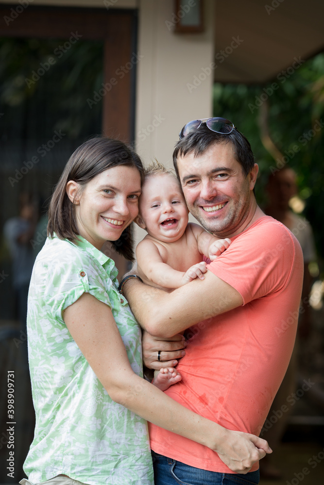 Beautiful young family laughing and hugging with their little son Beautiful young family laughing and hugging with their little son