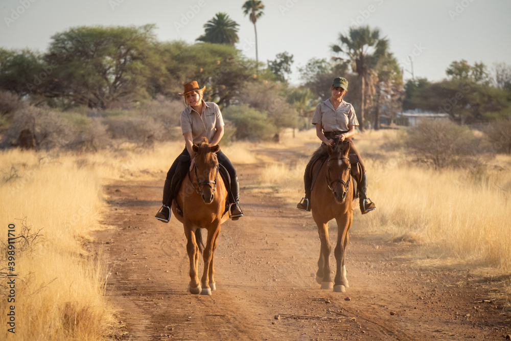 Blonde strokes horse on track beside brunette Blonde strokes horse on track beside brunette