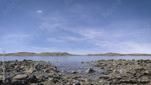 Peaceful lake scene in the afternoon with wispy clouds and blue sky reflecting in the still water. A calm, tranquil and serene, natural landscape.   photo