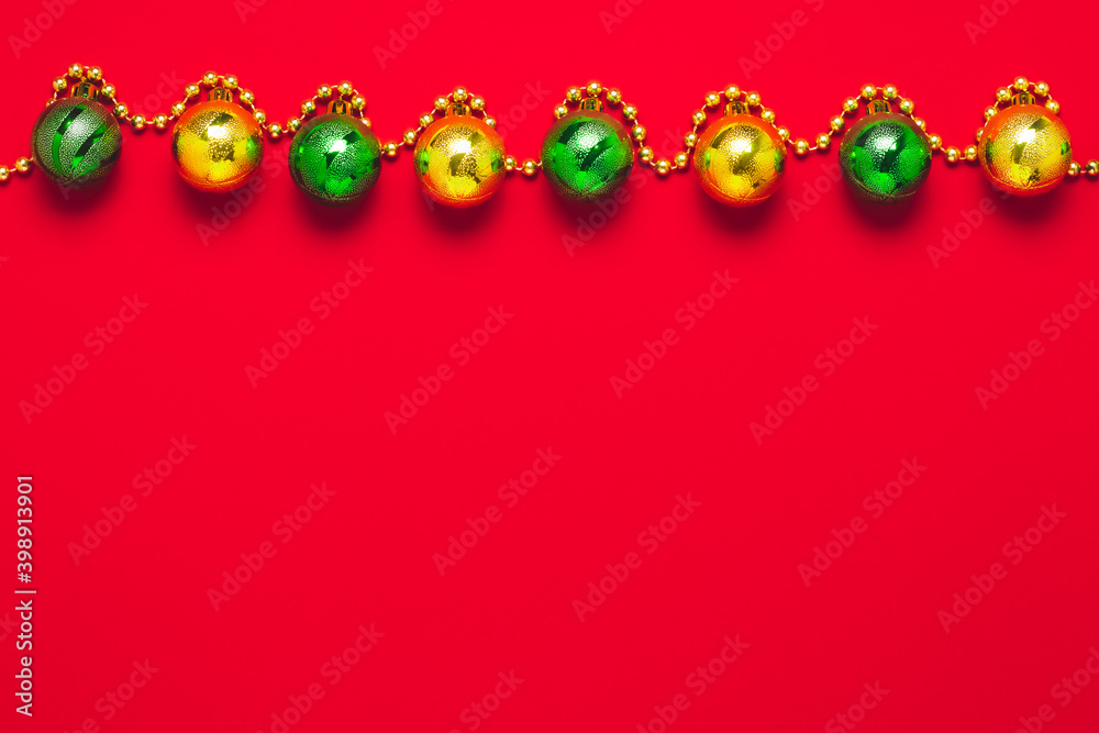 Red festive background with gold and green balls. Copy space on the holiday gift card. Winter decorations on Christmas template, bright minimal design. Shiny spheres on a New Year's mockup. Red festive background with gold and green balls. Copy space on the holiday gift card. Winter decorations on Christmas template, bright minimal design. Shiny spheres on a New Year's mockup.