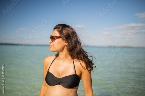 Beautiful woman standing with the blue sea and sky as background
