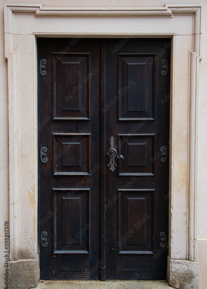 An old richly decorated wooden door set into a stone portal in the Warsaw Old Town