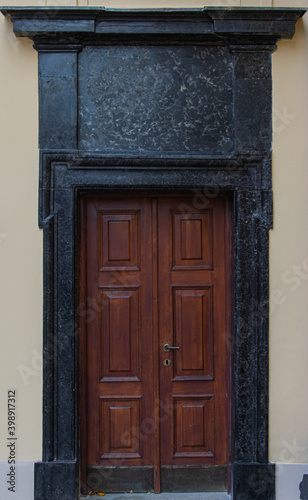 An old richly decorated wooden door set into a stone portal in the Warsaw Old Town
